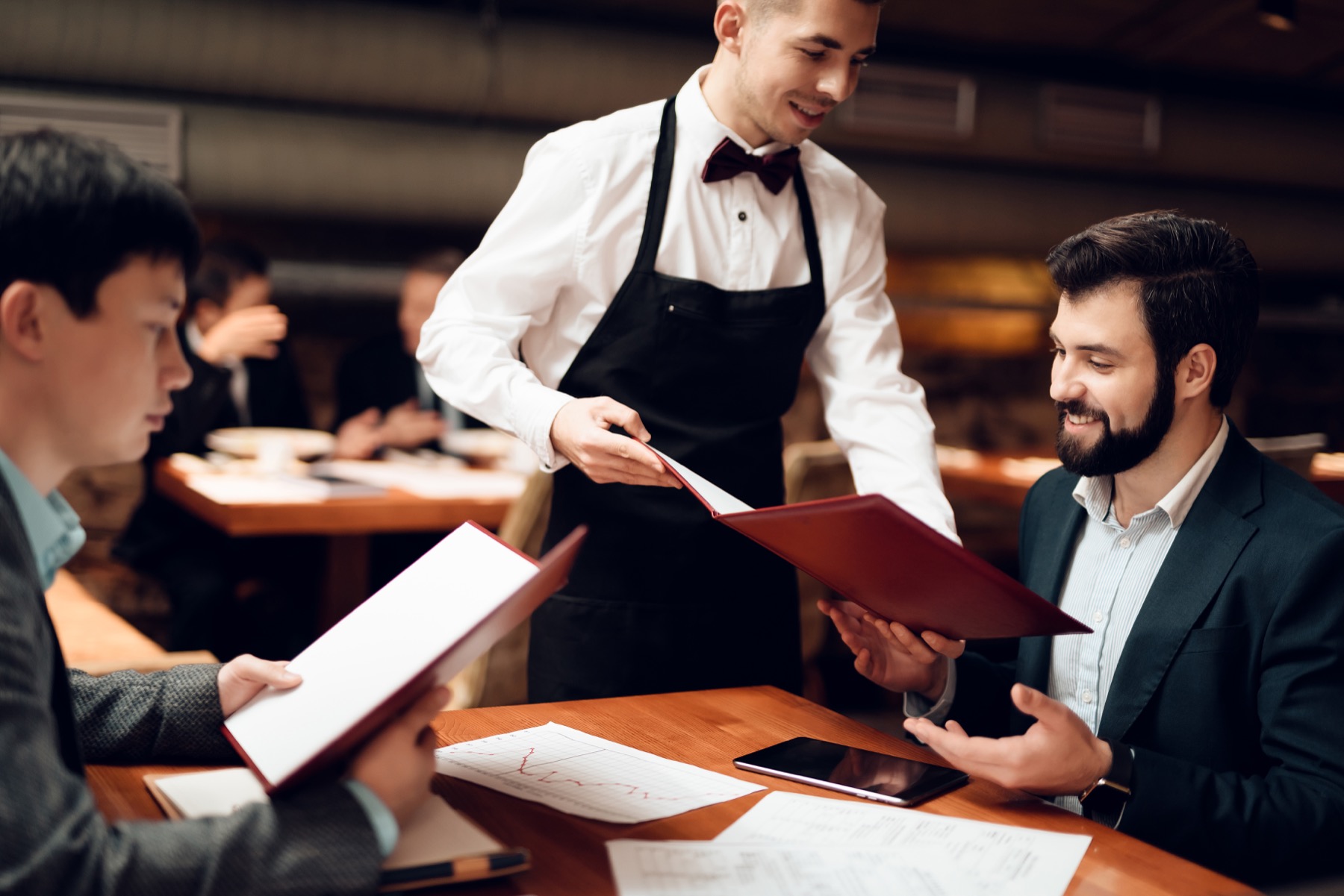 Server presenting the menu to guests