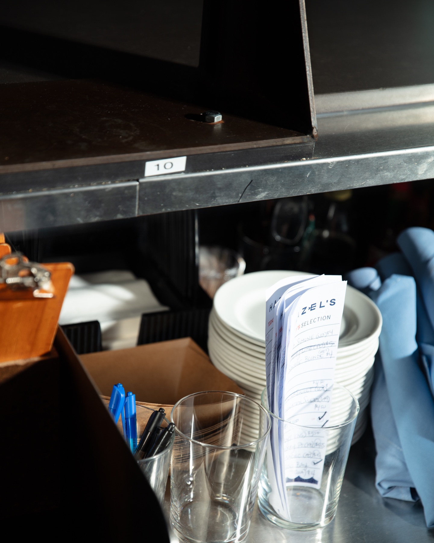 Back-of-house station with menus, glassware, and plates ready for service