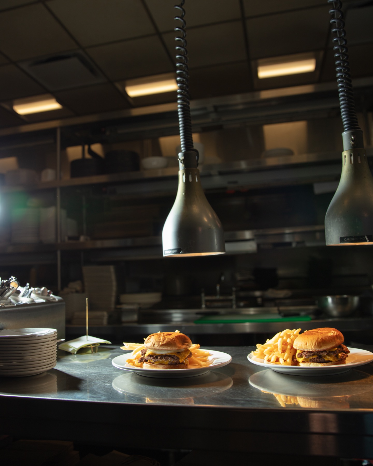 Burgers under the heat lamps at the kitchen pass